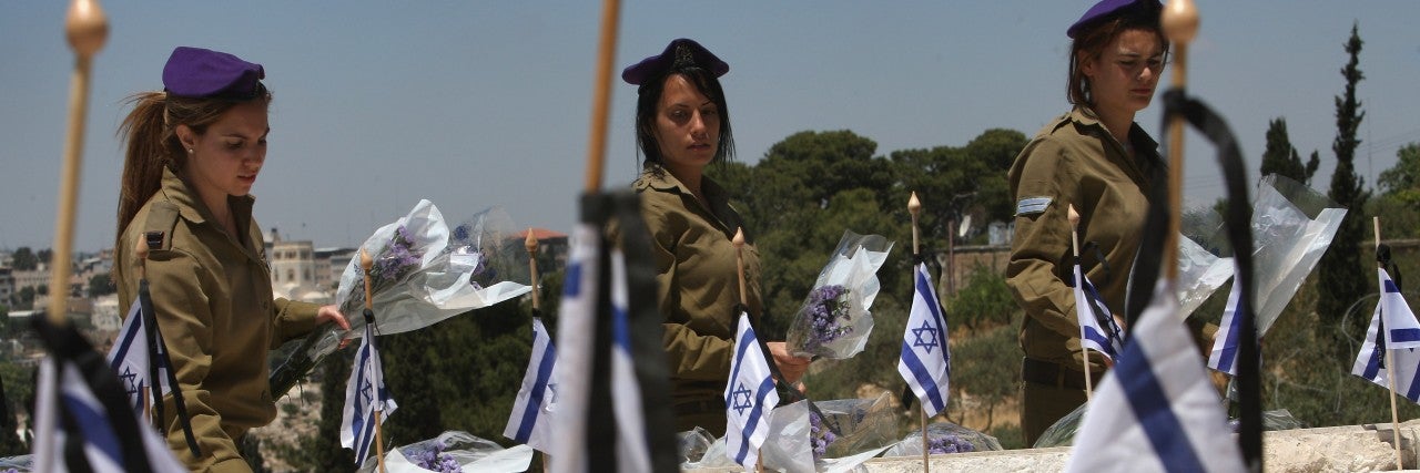 Photo of Israeli Soldiers at a memorial with Israeli flags